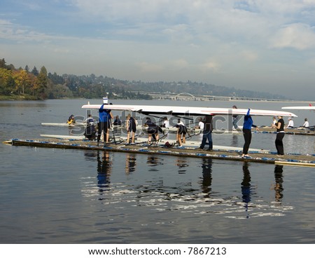 A team of rowers preparing to lower their shell into the water before a race on Lake Washington.