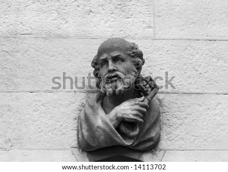 A stone carving of Saint Peter above the main door on the outside of the Chapel Royal in Dublin. He is holding the traditional symbols of cross and key. (In black and white.)