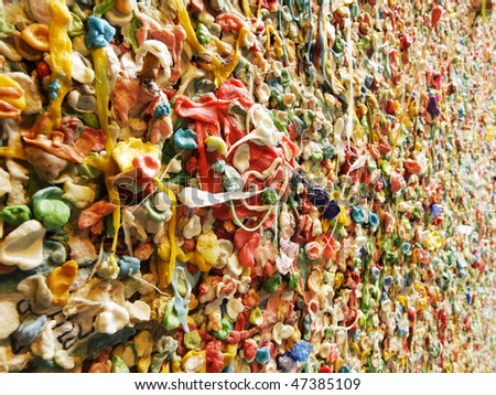 A detail view of part of the famous bubble gum wall in Post Alley near the Pike Place Market in Seattle. This landmark has built up layers of chewing gum over the years in colorful abstract pattern.