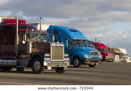 Tractor-trailer trucks in a line at a rest stop
