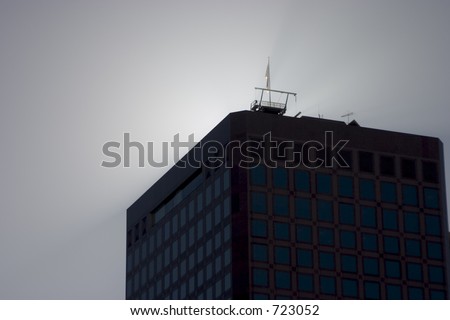 The morning sun streams over the top of a building, giving the impression of \