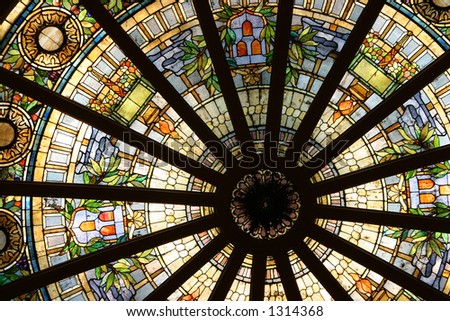 An ornate stained glass dome, viewed from below.