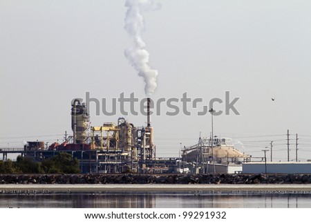 Geothermal Energy Plant with steam coming out. Seen from a distance with heat distortion.