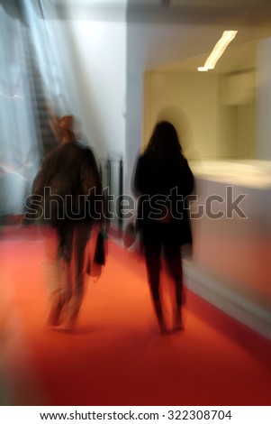 two people walking indoor in a corridor