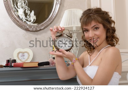 Young attractive girl about mirrors with antique clock hands
