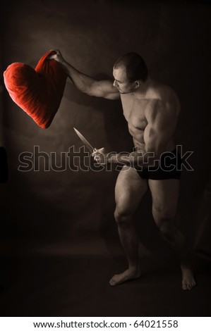 Muscular man with knife attacking red heart