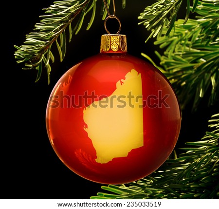 A red bauble with the golden shape of  Western Australia hanging on a christmas tree isolated on black.(series)