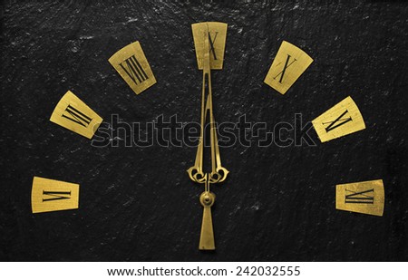 Black clock with golden arms indicating it\'s about time.