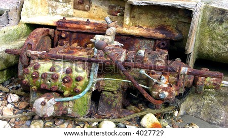 Grungy old auto engine rusting away on the beach