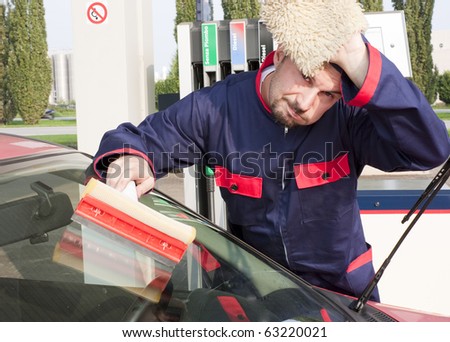 Gas Station Worker Cleaning Windshield at Service Station