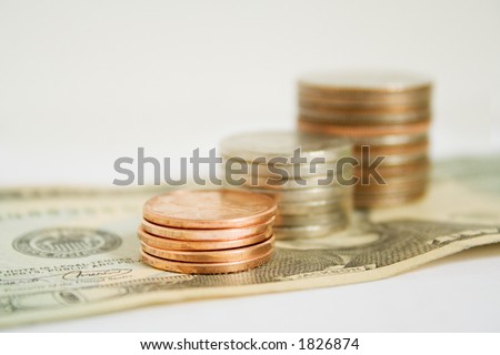 Stack of US coins on top of a US twenty dollar bill.
