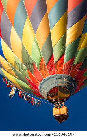 RENO - SEPTEMBER 7: A colorful hot air balloon rises into the clear blue sky during the mass ascension at the 38th annual Great Reno Balloon Race in Reno, Nevada on Sept. 7, 2013