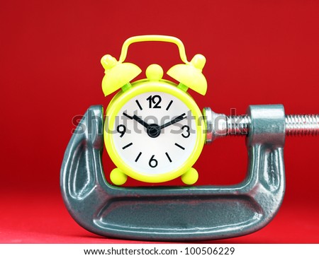 A lime green alarm clock placed in a Grey clamp against a pastel blue background, asking the question do you manage your time effectively.