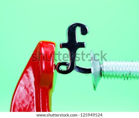 A silver pound symbol placed in a red clamp with a pastel green background, indicating the pressure on the pound sterling
