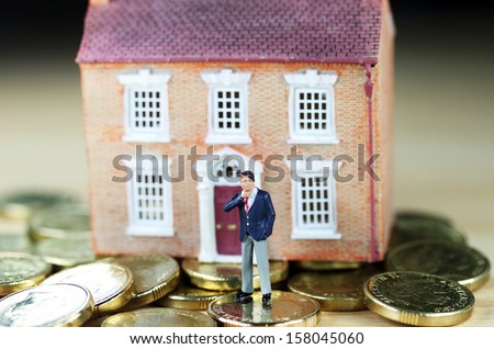 A real estate agent in front of a house  resting on gold coins, with a real thinkers pose, suggesting you have to find the buyers green button!