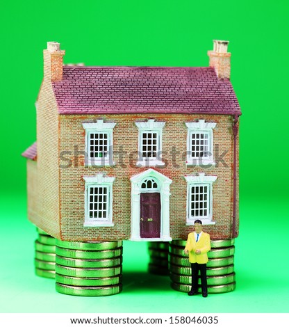 A real estate agent in front of a house on gold coin stilts, asking the question how much money will you have to invest to purchase this property?
