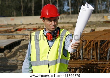 Engineer waving the blueprints furiously and looking annoyed on the work site, wearing red helmet, red earmuffs and reflective yellow vest