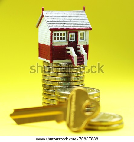 A house placed on a pile of gold coins with a golden key in front , asking the question is it time to buy that dream house?