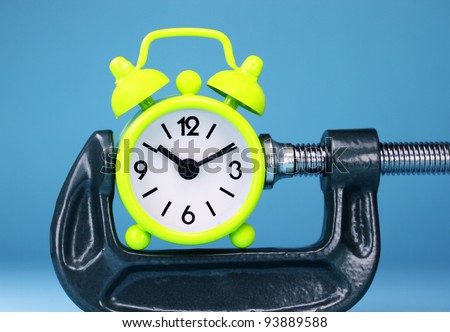 A lime green alarm clock placed in a Grey clamp against a pastel purple background, asking the question do you manage your time effectively