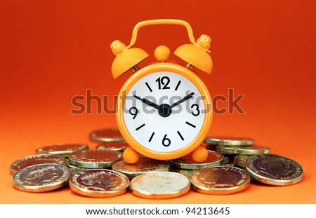 An orange colored  alarm clock placed in a Grey clamp against a pastel blue background, asking the question do you manage your time effectively.