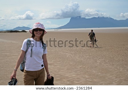 Cheerful Asian girl smiling in the sunshine at the beach of Bako National Park, Sarawak, Malaysia.