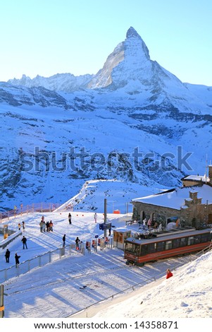 The train station in Gornergrat, at the Swiss Alps with the Matterhorn in the background as the sun begins to set.