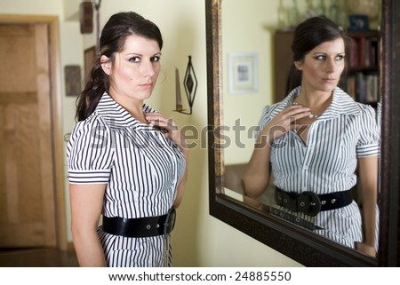 Woman standing next to mirror inside a home