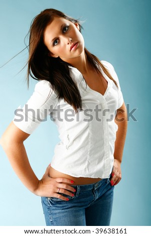 Young woman poses in casual blouse and jeans