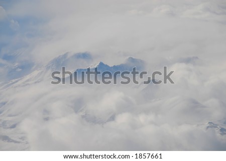 Sierra Mountains in the clouds viewed while flying at 28,000 feet