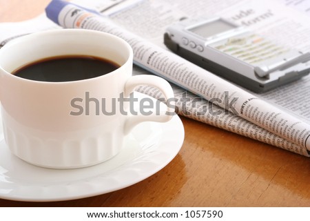 coffee, cellphone and newspaper on work table