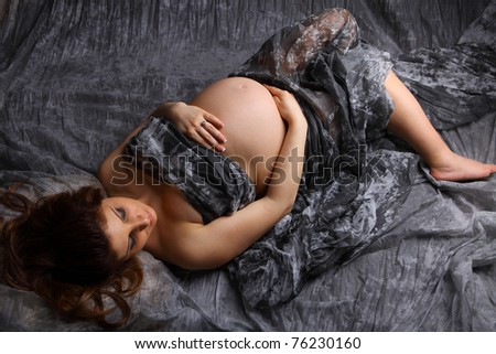 Beautiful Pregnant woman with an overhead shot holding her bare tummy