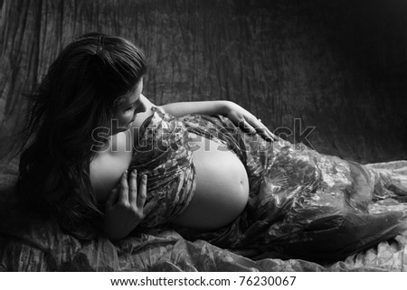 Beautiful Pregnant woman laying on the floor on black and white
