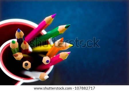 Various Colored Pencils isolated on blue background. Macro with extremely shallow depth of field