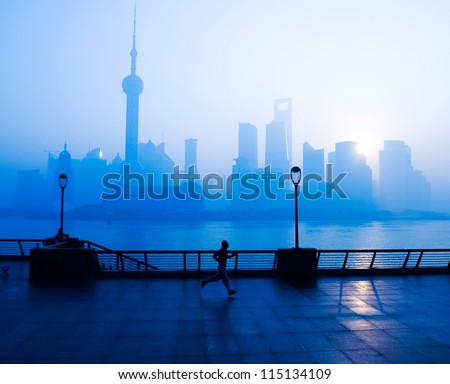 SHANGHAI - NOV. 21:Unidentified man jog on the Bund , Oriental Pearl Tower in the distance, on November 21 morning, 2010 in Shanghai, China.  One of the Top Ten Shanghai Attractions.
