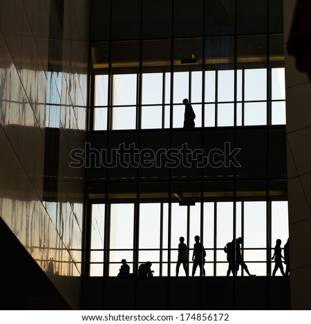 silhouettes of business people rushing at morden office building.