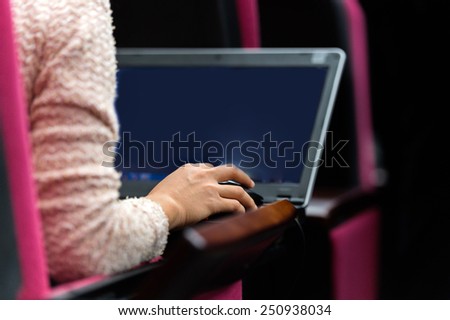 Business people typing on laptop keyboard at conference.