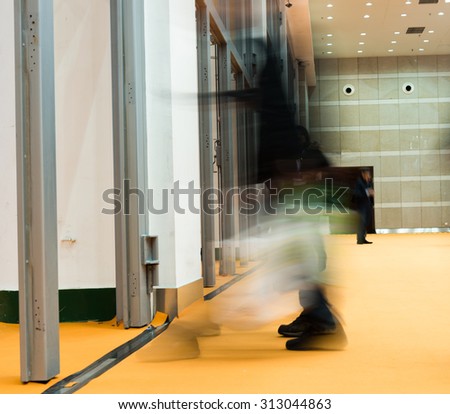 Business people rushing in a international exhibition. motion blur