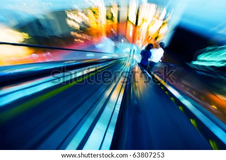 two people in two ways escalator,  because of photo shot by motion blur, the people can\'t be identify.