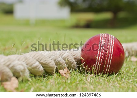 Close up Cricket ball on field touching boundary rope four runs with copy space