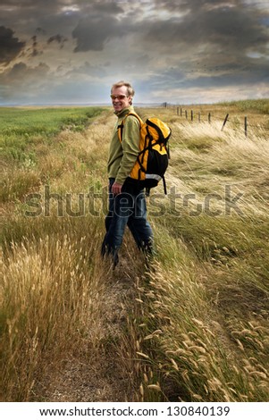 Man looking back and smiling on a prairie country road