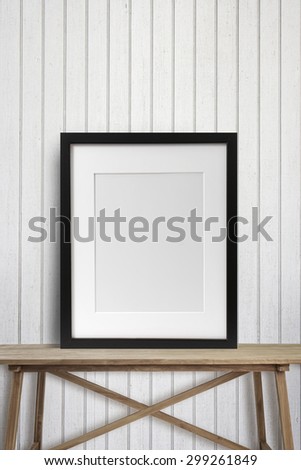 Black picture frame with on wooden table