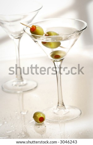 Martinis with green olives on bar counter