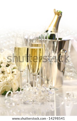 Glasses of champagne, roses, and a bottle of champagne