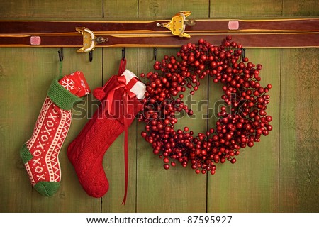Christmas stockings and wreath hanging on rustic wall