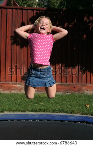adorable young girl jumping on trampoline