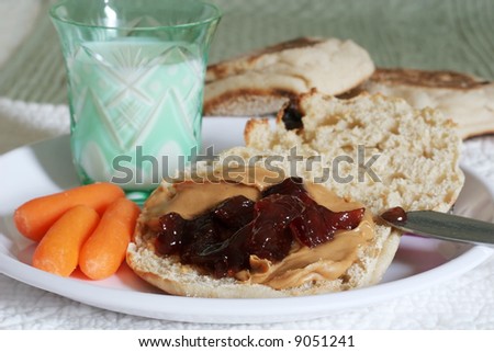 peanut butter and jelly on toasted muffin with carrots and milk
