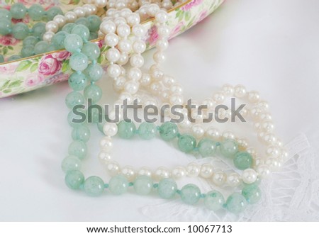 beautiful jade necklace and pearl necklace cascading from floral container