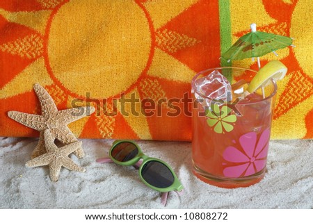 beach scene with colorful towel, starfish, sunglasses, and tropical drink on sand