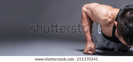 Young asian man workout over grey background with copy-space