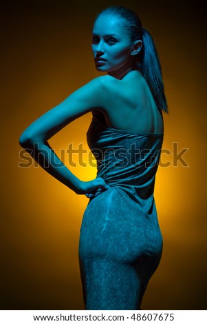 Glamorous image of fashion model in studio shot with colored gels for special effect
